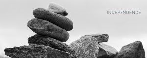Black and white close up of pile of river stones with the words INDEPENDENCE