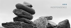 Black and white close up of pile of river stones with the words INDEPENDENCE